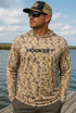 Angler wearing HOOKSET Timber Duck camouflage fishing hoodie featuring UPF 50 sun protection and lightweight performance fabric