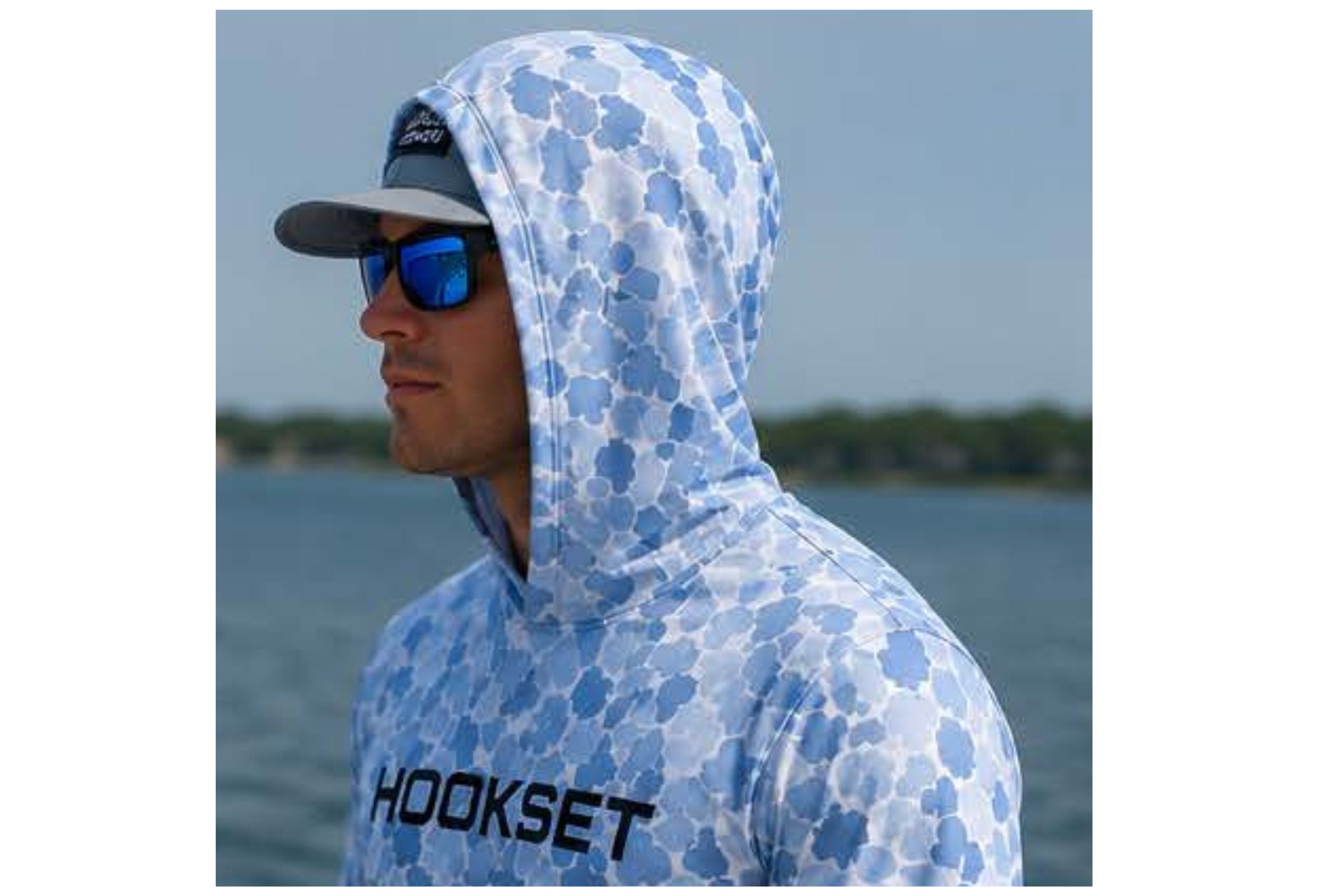 Hookset Blue Ice UPF 50 fishing hoodie with hood up near water