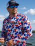 Man fishing on a boat wearing Hookset Freedom UPF 50 fishing hoodie with patriotic red white and blue duck camo pattern.