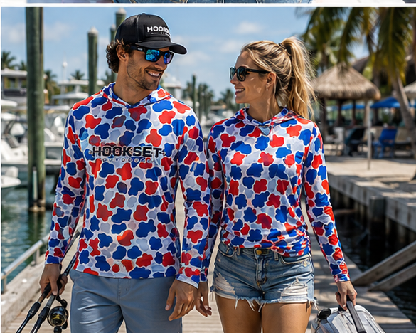 Man and woman wearing Hookset Freedom UPF 50 fishing hoodies on a marina dock.