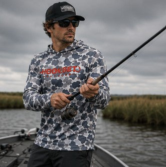 Man fishing on a boat wearing Hookset Storm Grey UPF 50 fishing hoodie.