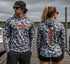 Man and woman wearing Hookset Storm Grey UPF 50 fishing hoodies on a marina dock.